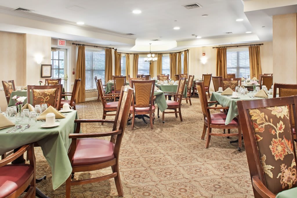 A well-arranged dining room with tables and chairs set for a meal.