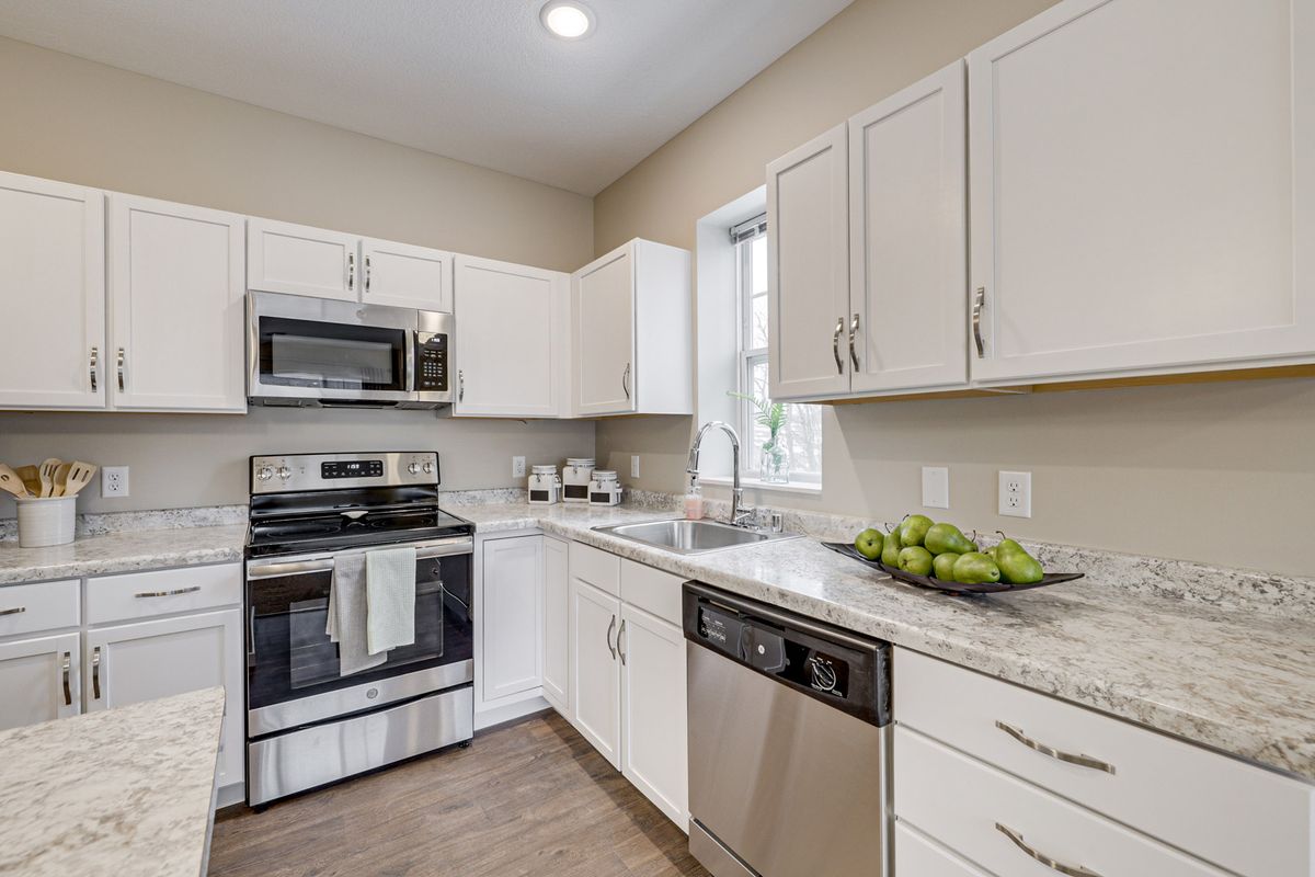 A modern kitchen with stainless steel appliances and white cabinets.