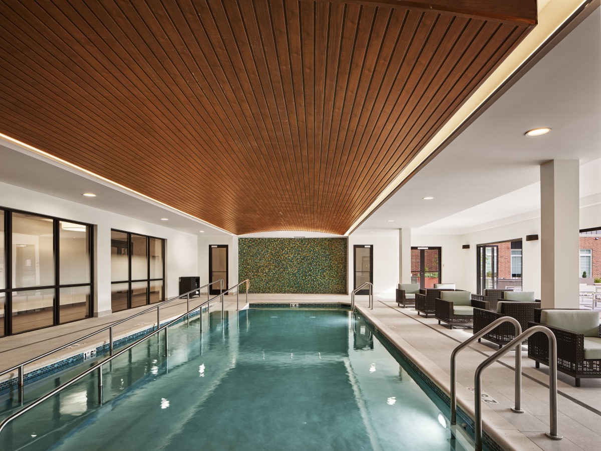 A luxurious indoor pool with modern design elements and a relaxation area.