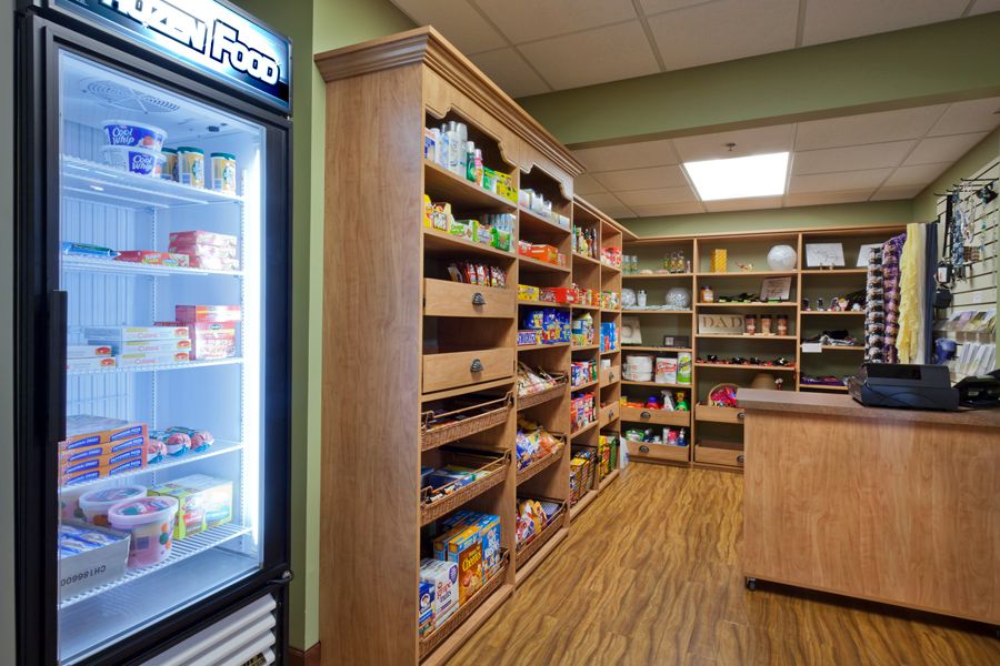 A small grocery store with shelves stocked with various products and a refrigerator.