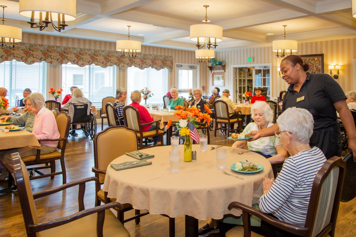 Residents enjoying a meal together in a senior living dining area.