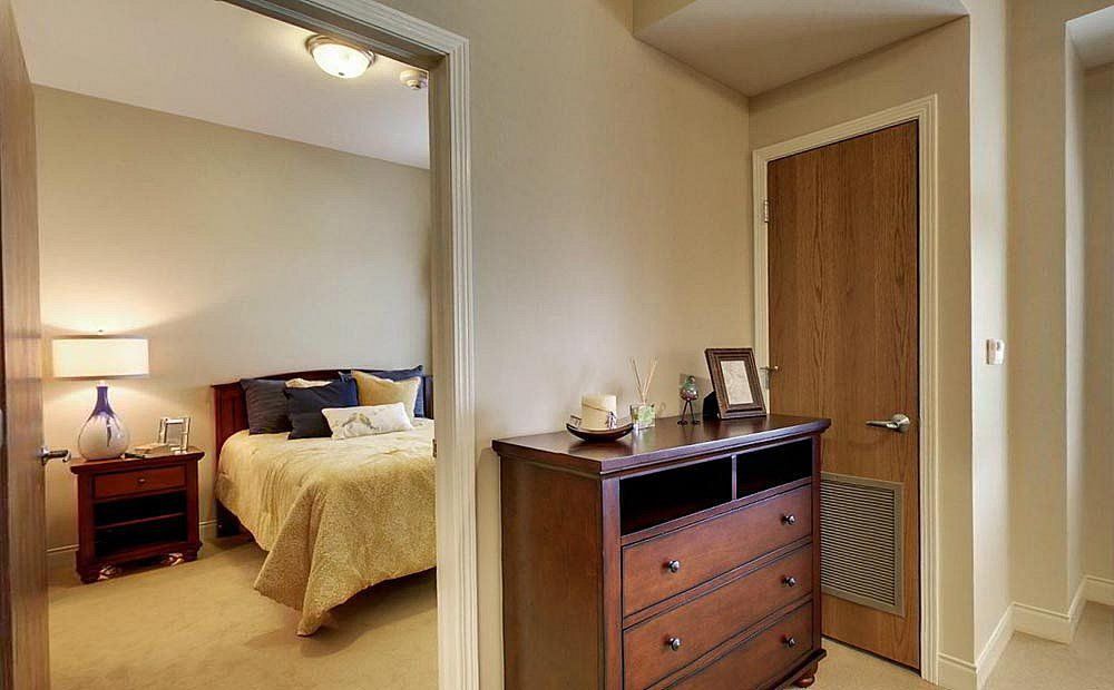 A cozy bedroom with a wooden dresser and an inviting bed.