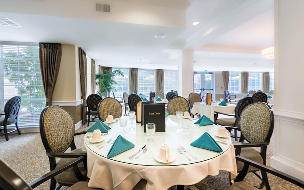 An elegantly set dining table in a well-lit restaurant interior.