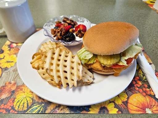 A delicious meal featuring a burger, waffle fries, and a side salad.