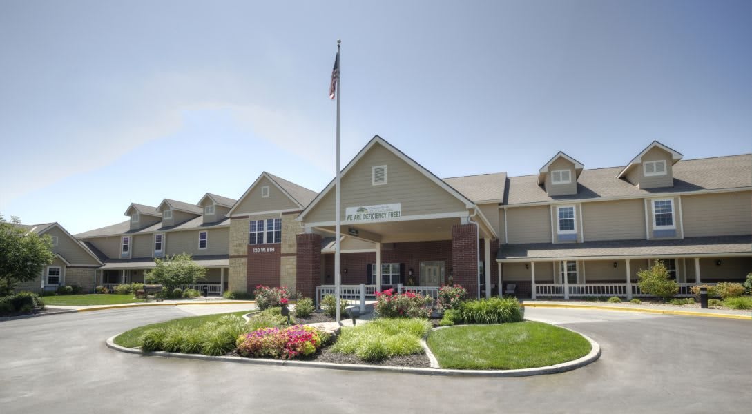 A well-maintained building with a landscaped garden and an American flag at the entrance.