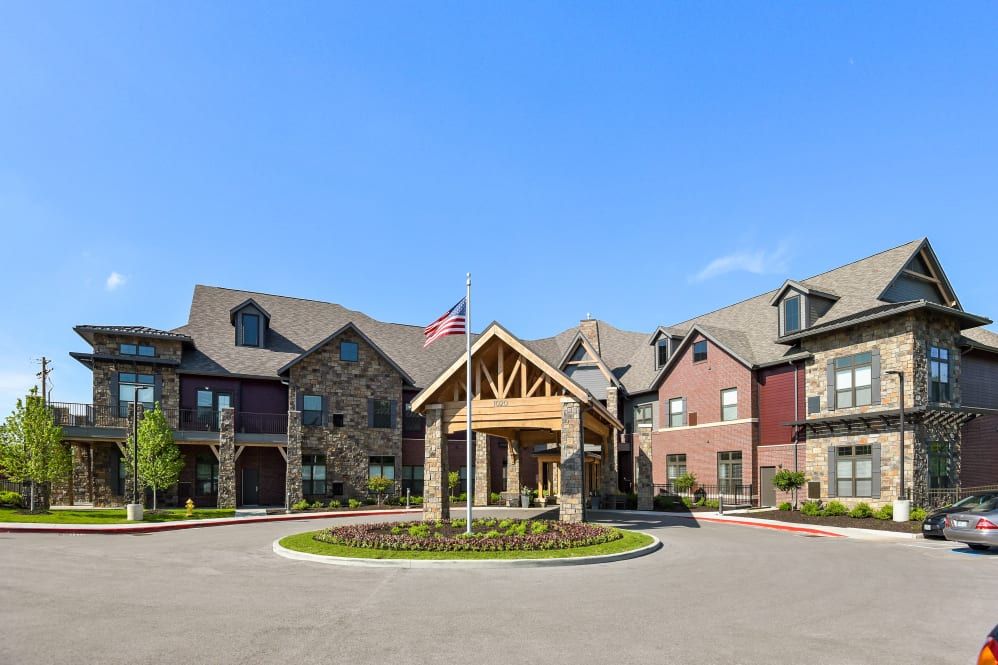 A beautiful residential building with a stone facade and a welcoming entrance, featuring a flagpole in front.