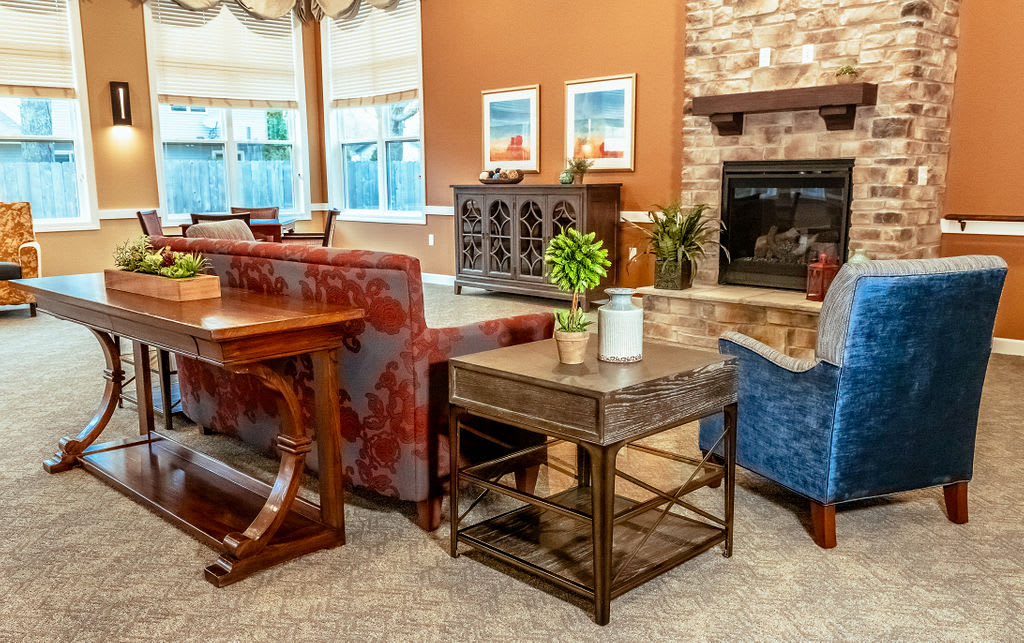 A cozy living room with warm colors, featuring a fireplace, comfortable seating, and decorative elements.