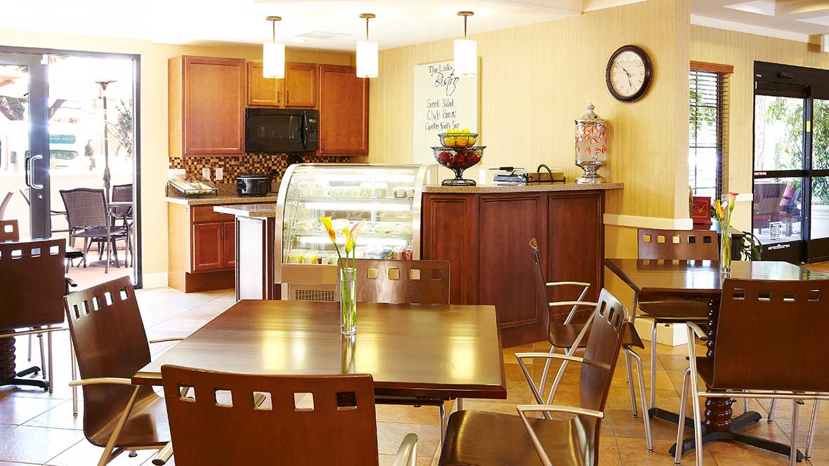 A cozy cafe interior with wooden furniture and a display case.