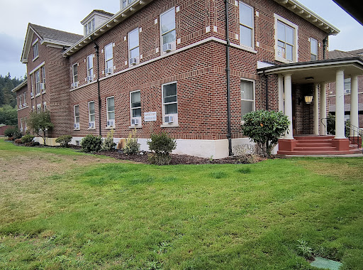 A brick building with well-maintained grass and an inviting entrance.