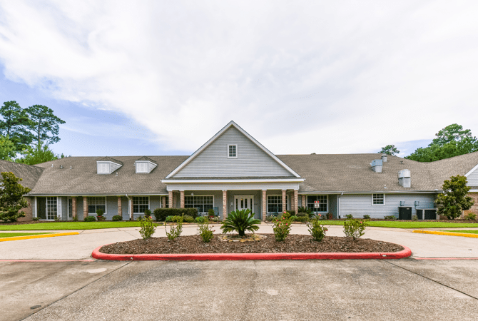 A residential building with landscaped surroundings and a driveway.