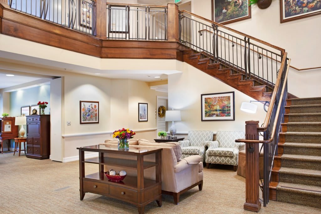 A spacious living area featuring a wooden staircase and elegant furniture.