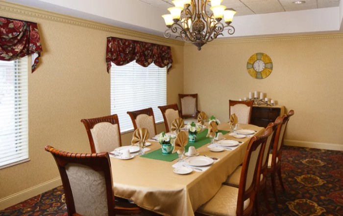 An elegantly decorated dining room with a chandelier and a fully set table.