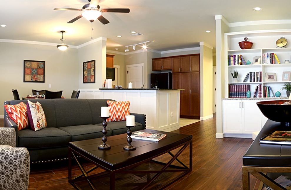 A modern living room with an open kitchen, featuring a sofa and a coffee table.