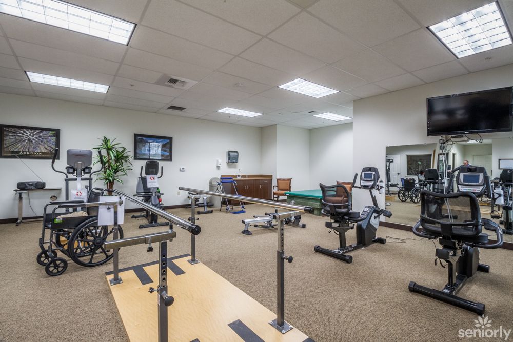 A physical therapy room equipped with various exercise machines and rehabilitation equipment.