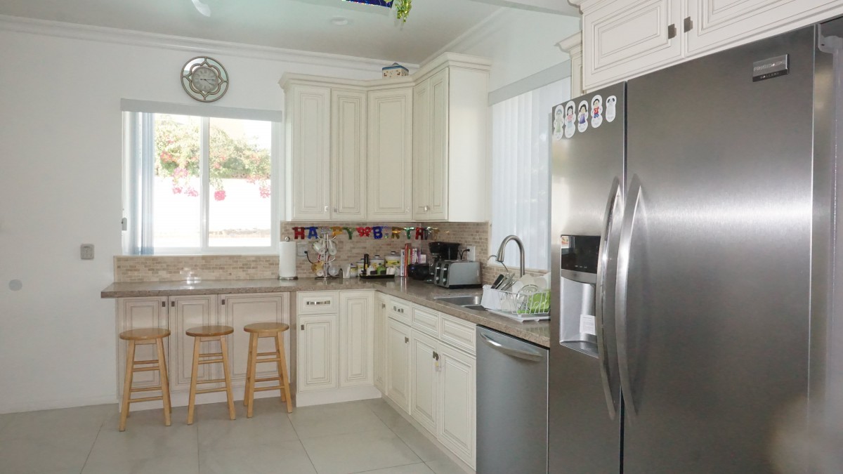 A modern kitchen with white cabinets and stainless steel appliances.