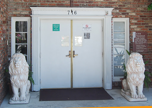 The entrance of a building featuring a pair of lion statues flanking the door.
