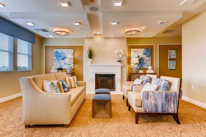 A modern living room with comfortable sofas, a central fireplace, and elegant decor.