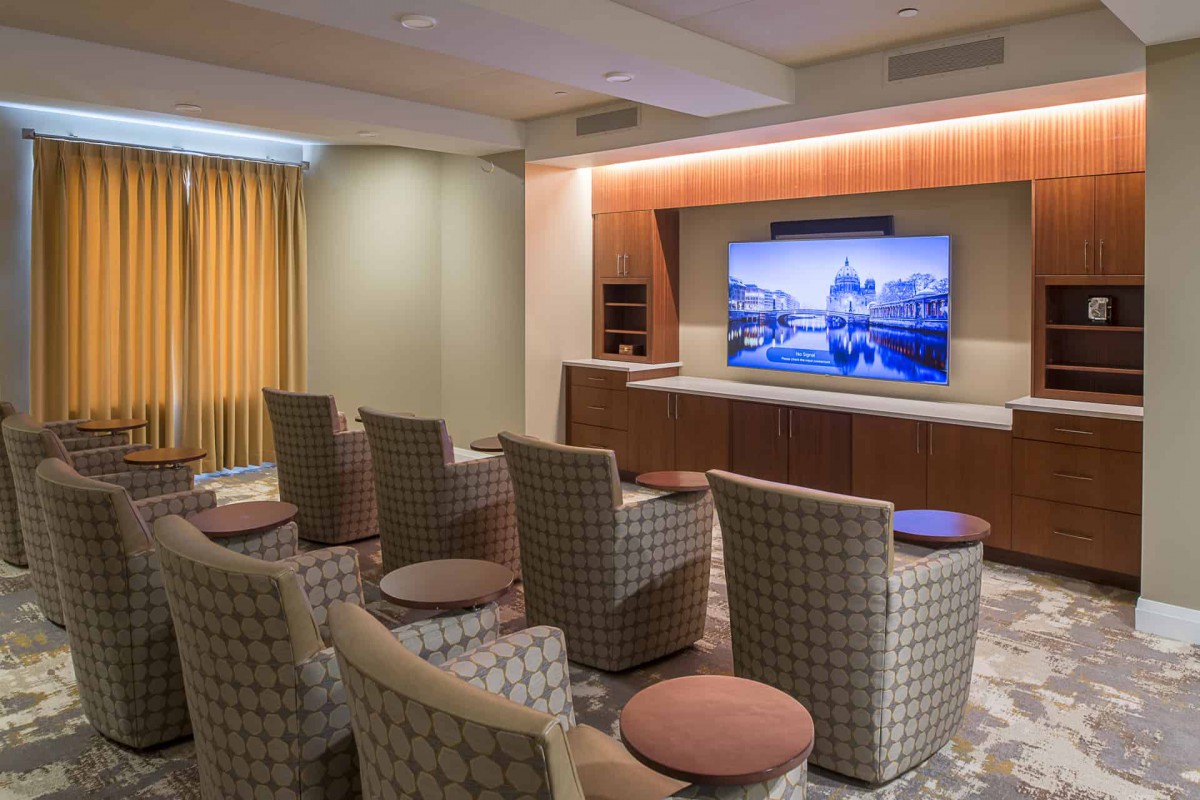 A cozy media room with comfortable chairs arranged in front of a large television screen.