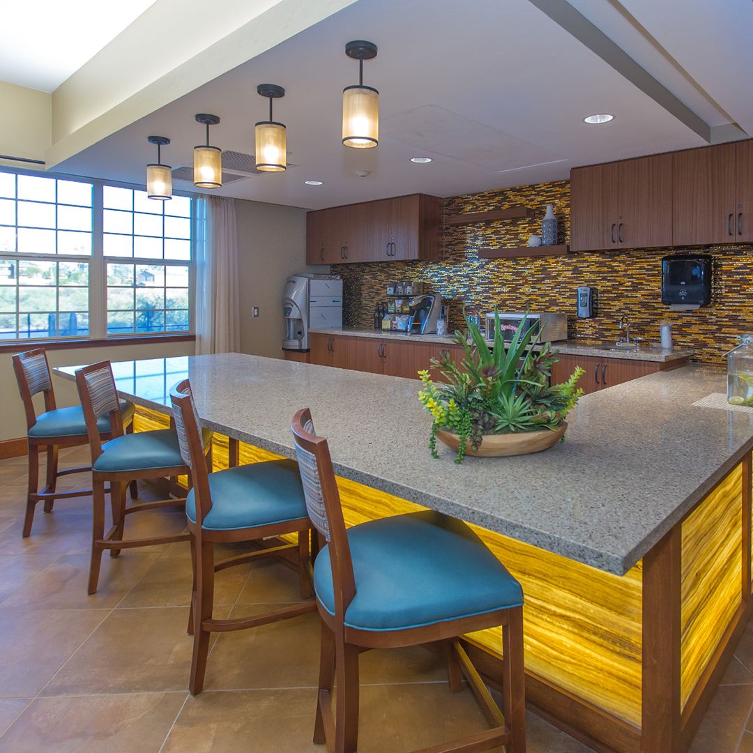 A modern kitchen interior featuring a central island with seating and stylish lighting.