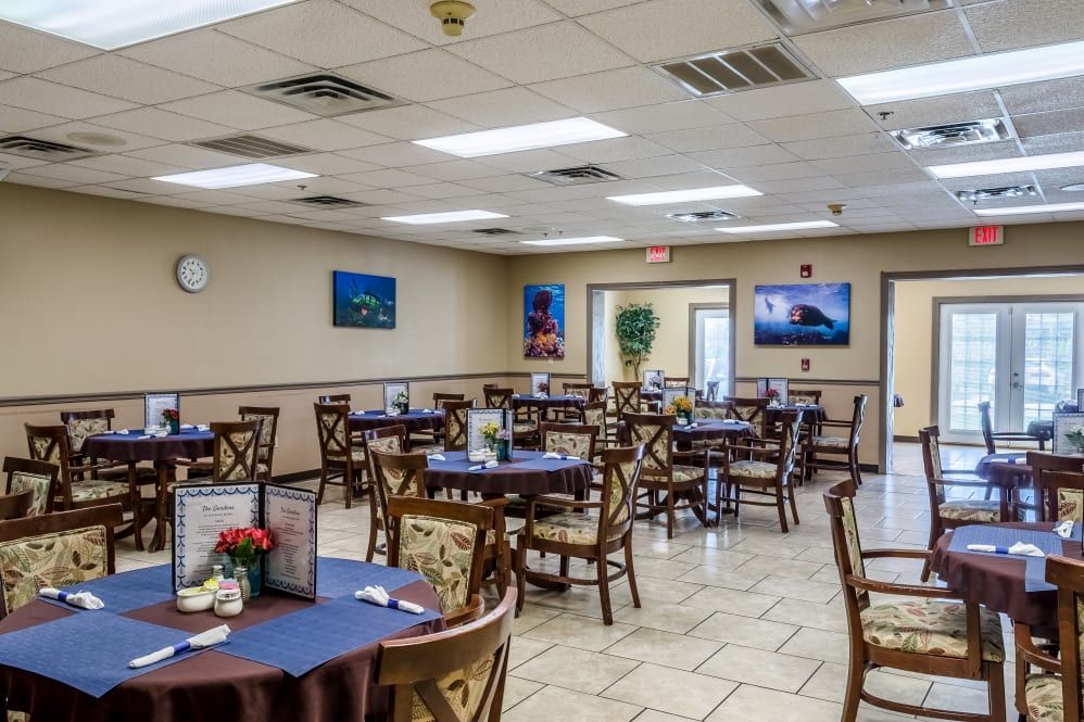 An empty dining room with neatly arranged tables and chairs, decorated with wall art.