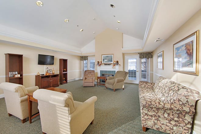 A spacious living room with comfortable seating, a television, and a fireplace.