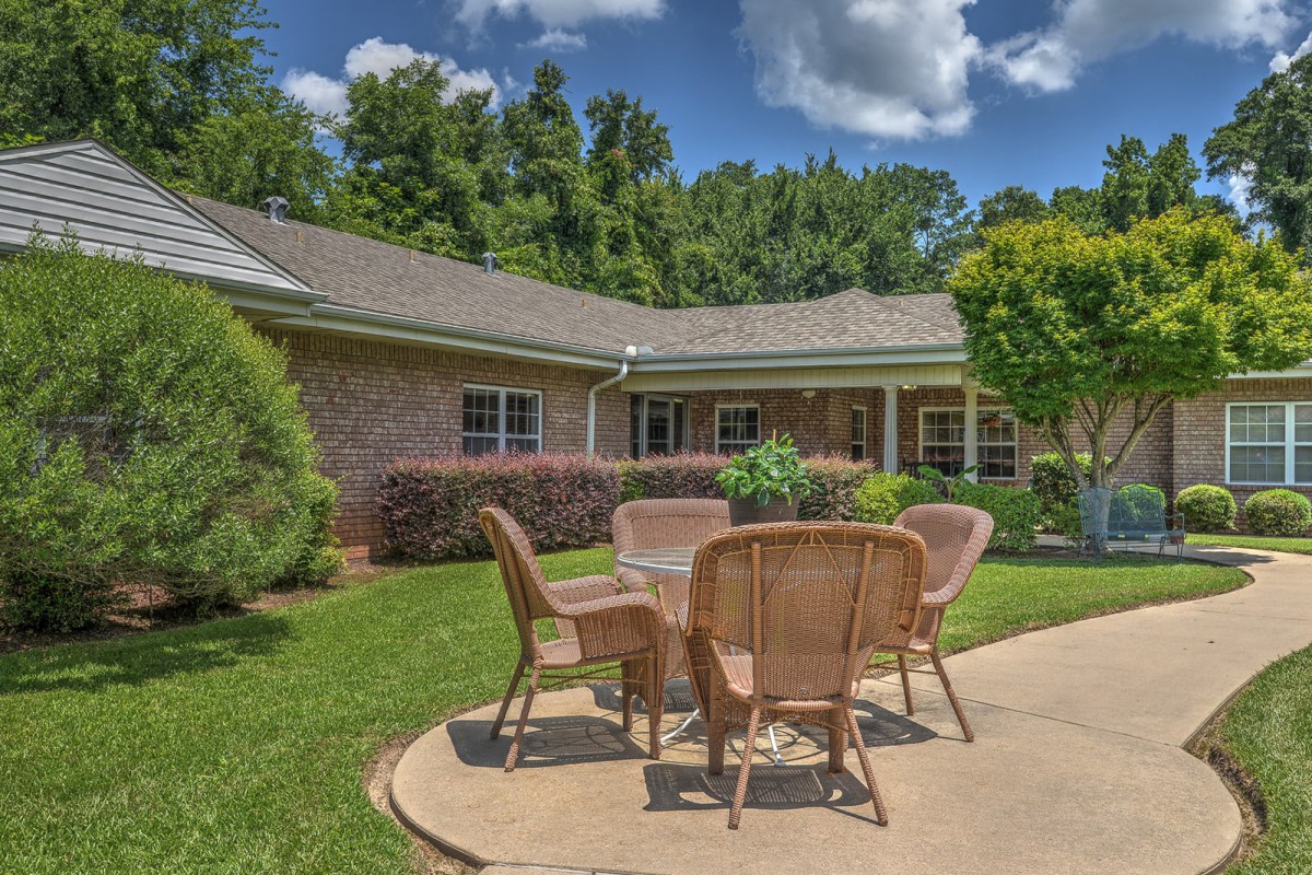 A beautiful patio with outdoor seating in a garden setting on a sunny day.