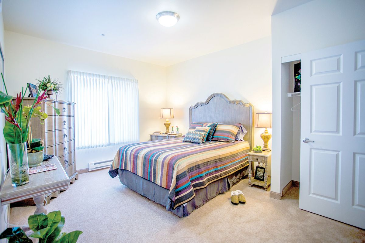 A cozy and bright bedroom with a patterned bedspread and elegant decor.
