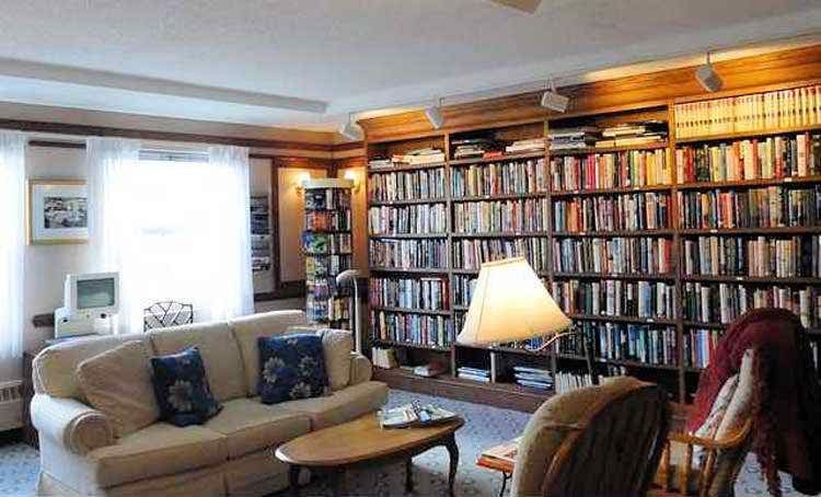 A cozy reading room with wall-to-wall bookshelves and comfortable seating.