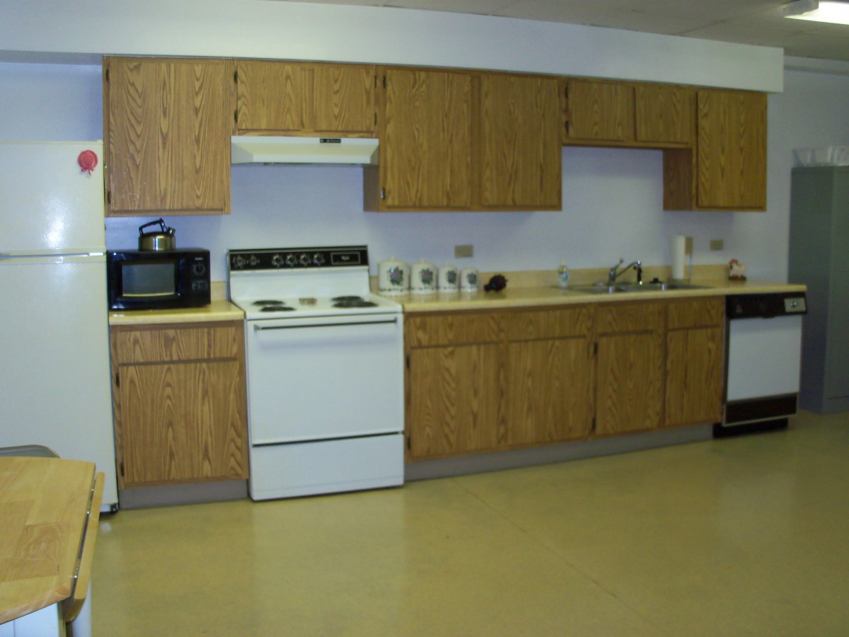 A kitchen with wooden cabinets and various appliances, including a stove and microwave.