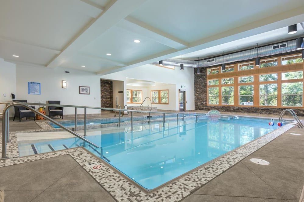 A modern indoor swimming pool with ample natural light and contemporary design.