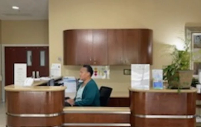 A person working at a reception desk in an office environment.