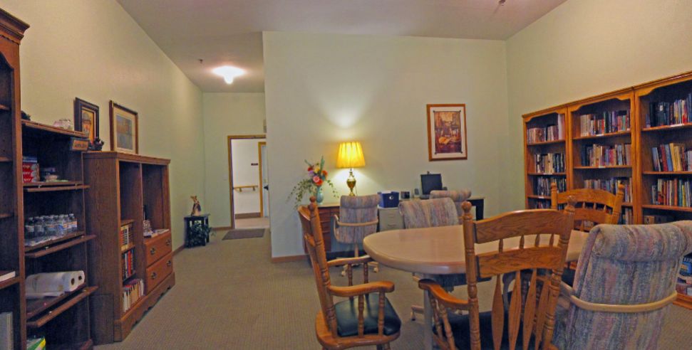 A cozy dining room with a wooden table, chairs, and soft lighting.