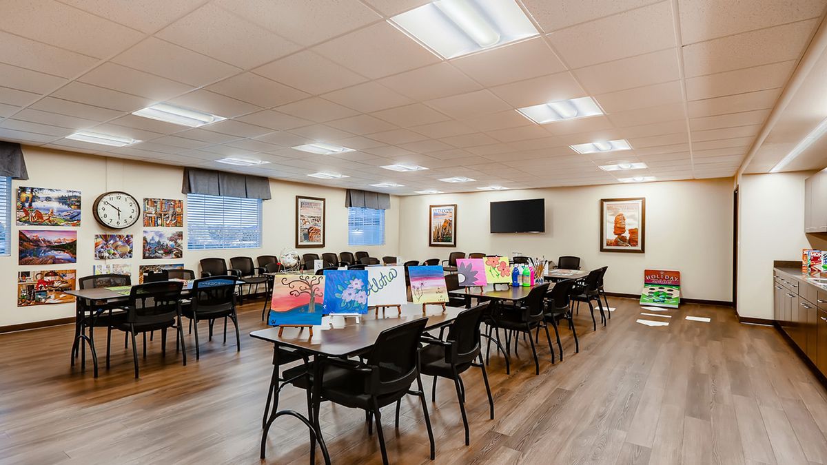 A well-lit conference room with tables and chairs, decorated with colorful artwork.