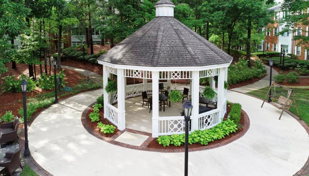 A charming gazebo surrounded by lush greenery in a serene garden setting.