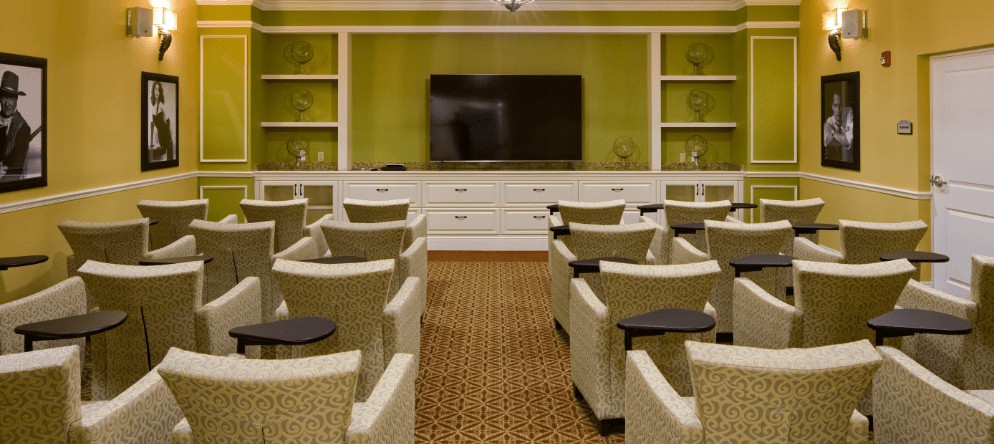A cozy conference room with comfortable seating and a large television for presentations.