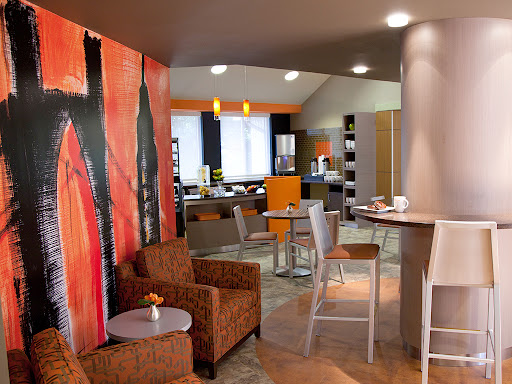 A modern lounge area featuring comfortable seating, vibrant wall art, and a cozy atmosphere.