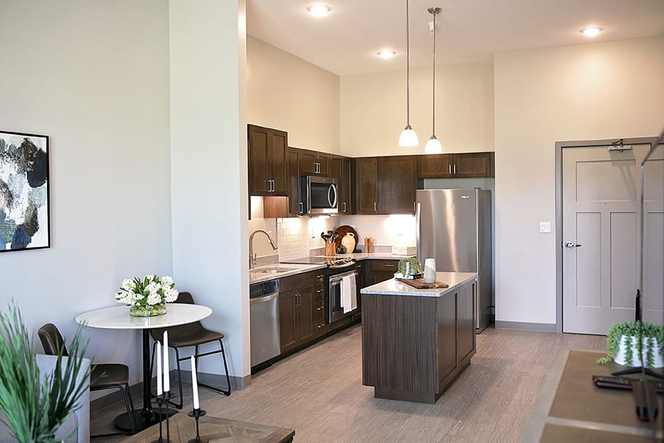 A modern kitchen with an island and stainless steel appliances.