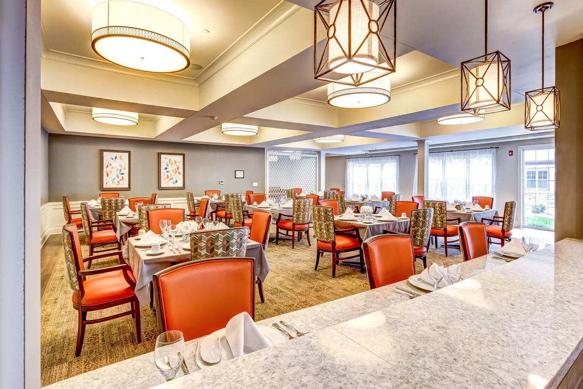 A well-lit restaurant dining area with neatly arranged tables and chairs.