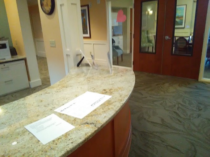 A reception desk with papers on a granite countertop in an office interior.