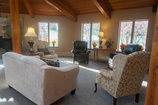 A cozy living room featuring a variety of seating options and plenty of natural light.