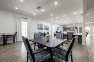 A modern dining area featuring sleek furniture, decorative paintings, and ample lighting.