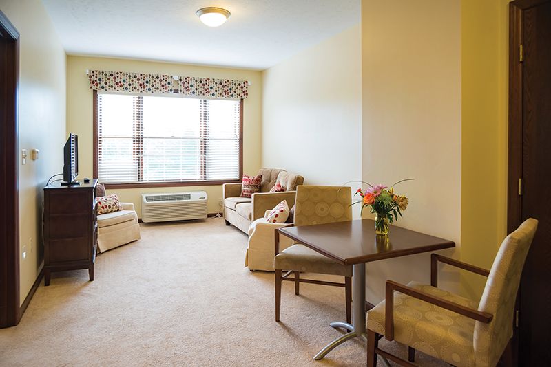 A cozy living room with comfortable seating and a table near a large window.