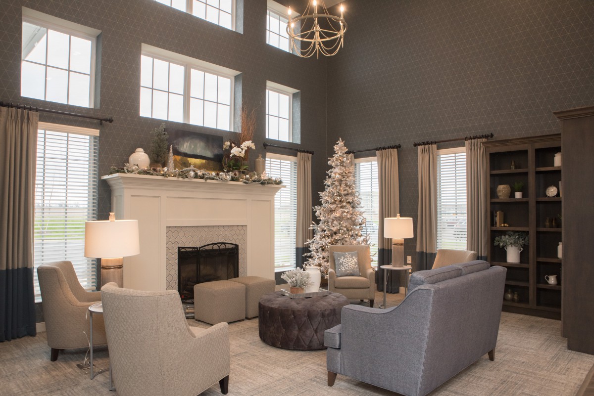 A beautifully decorated living room with a Christmas tree and fireplace, creating a cozy festive ambiance.