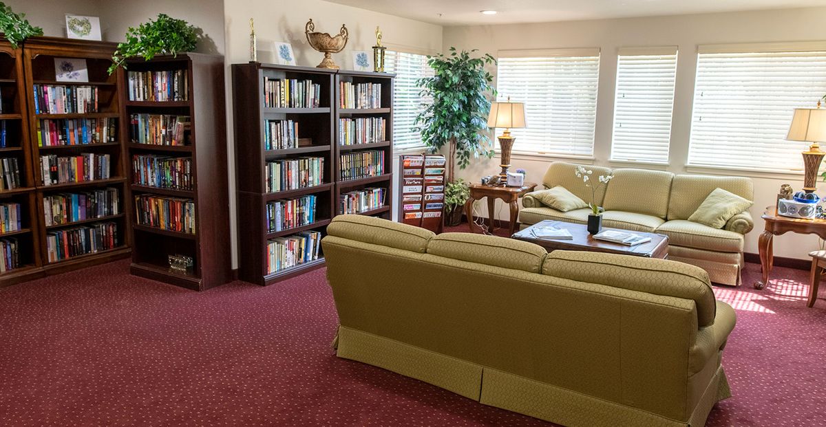A cozy living room with a bookshelf, sofa, and coffee table.