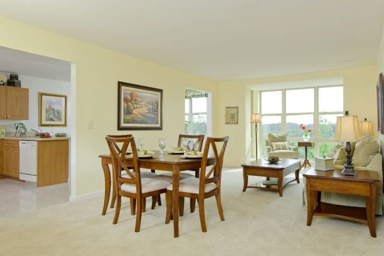 A bright and spacious dining room with wooden furniture and ample natural light.