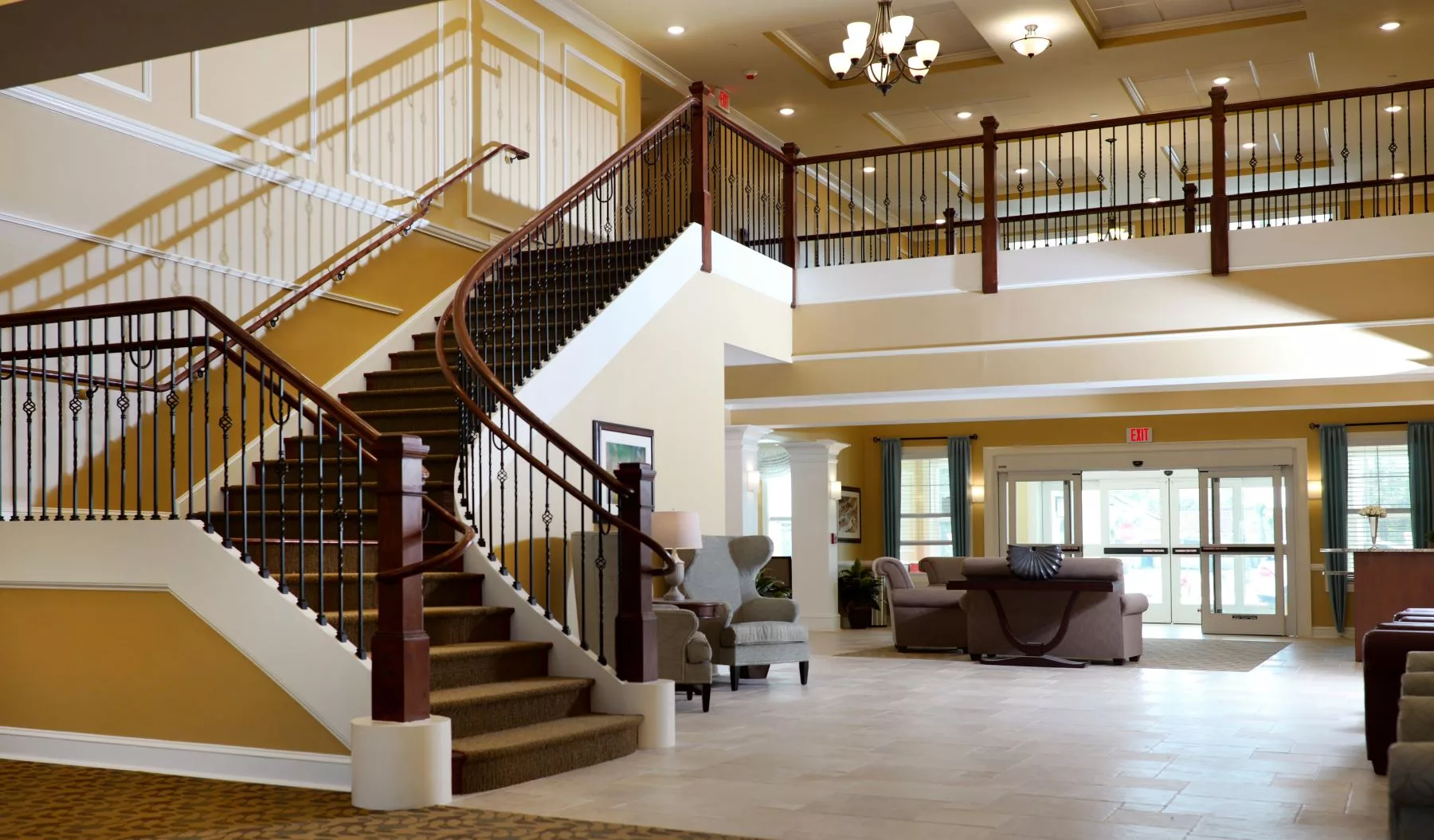 Spacious and elegant interior with a grand staircase and comfortable seating area.