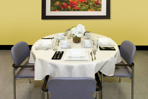 A beautifully arranged dining table with a white tablecloth and floral centerpiece in a cozy restaurant setting.