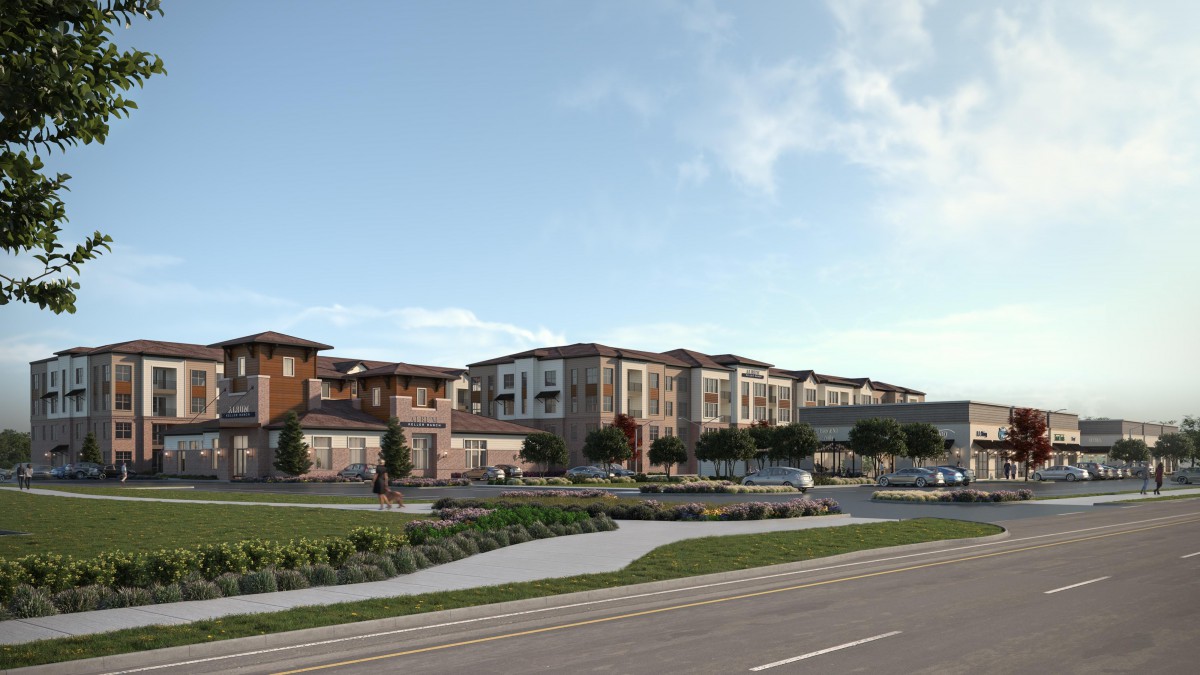 A modern residential complex featuring multiple apartment buildings with surrounding landscaping and a road in the foreground under a partly cloudy sky.