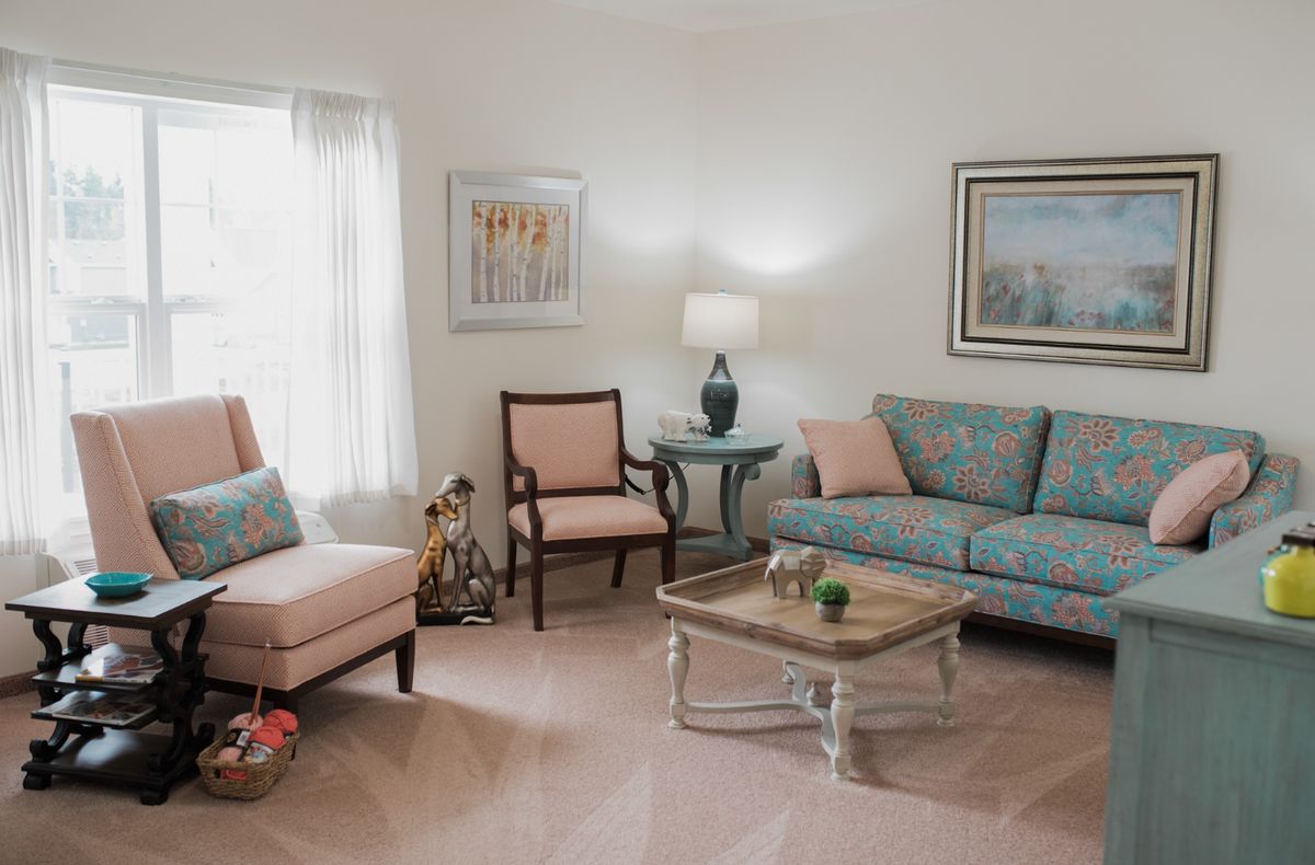 A cozy living room featuring a comfortable sofa, armchair, and a well-decorated interior.