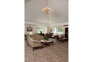 A spacious living room with elegant furniture and a chandelier.